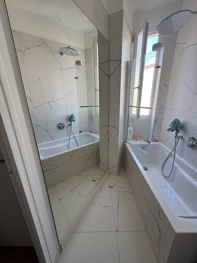 Salle de bains avec baignoire et douche de pluie