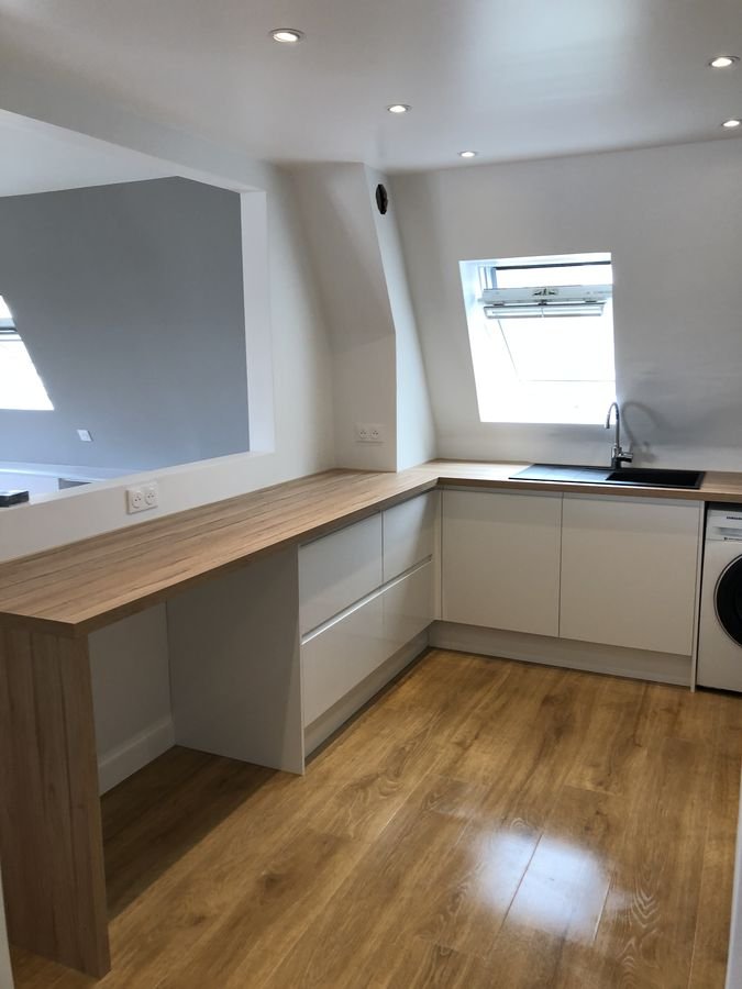 Cuisine sous combles avec plan de travail en bois et parquet