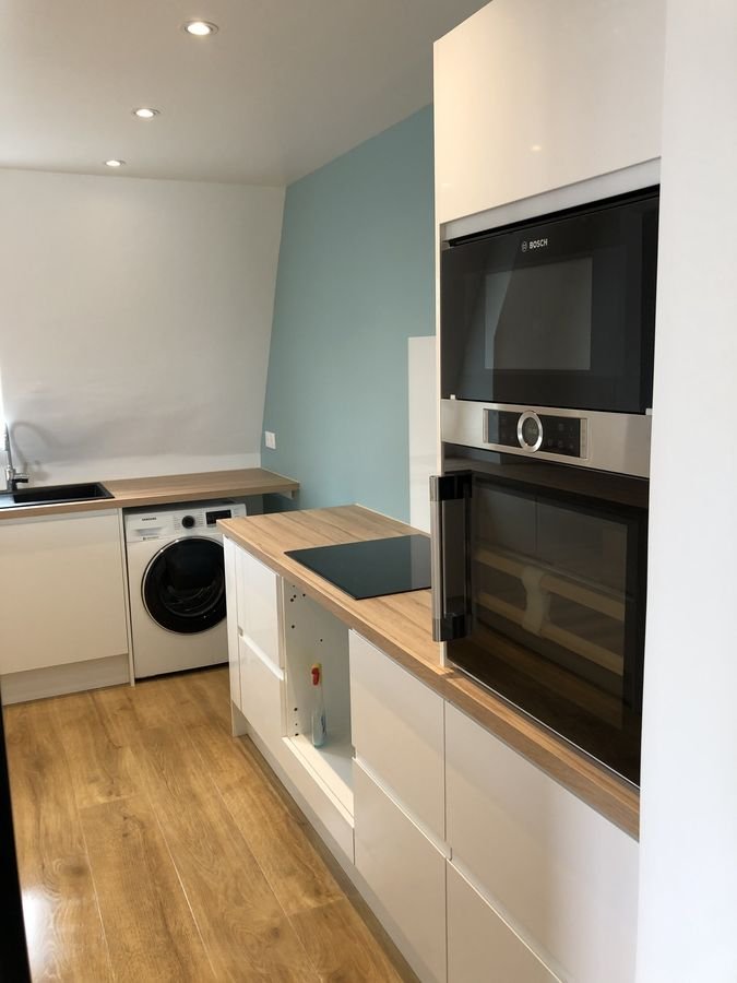 Cuisine avec four encastré et lave-linge sous le plan de travail