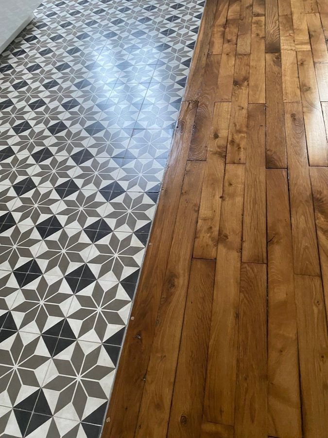 Carrelage à motifs géométriques et parquet en chêne