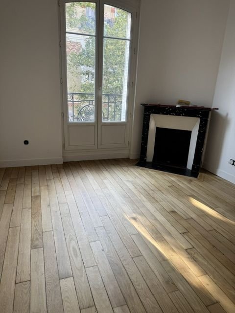 Parquet clair devant une cheminée en marbre
